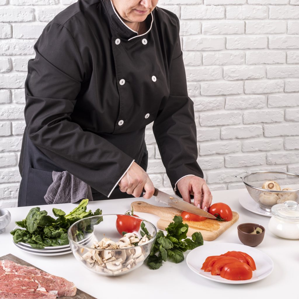 chef-mujer-cortando-tomates-para-plato